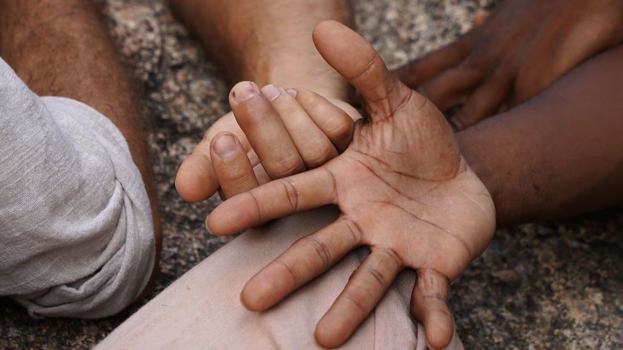 A hand resting in another person’s open palm.